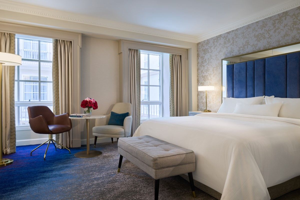 King bedroom with blue décor and a view overlooking The Atrium Lounge