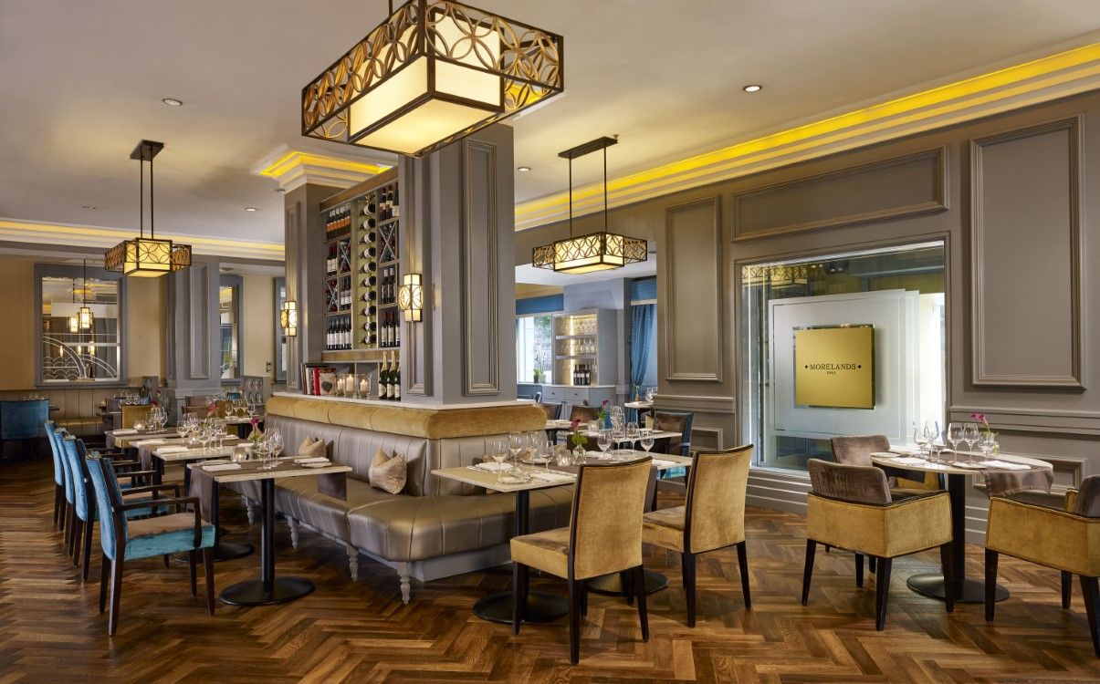 Restaurant tables set for dinner with gold and blue chairs in The College Green Hotel Dublin