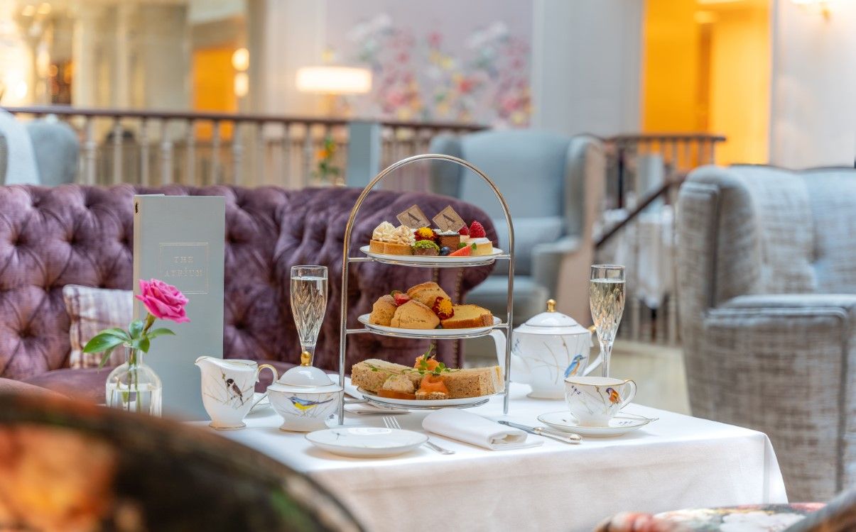 Champagne glasses with afternoon tea set up on white cloth