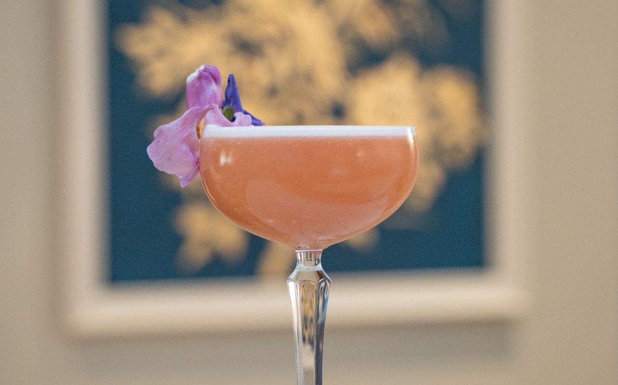 Pink cocktail with purple flower in coop glass in in The College Green Hotel Dublin