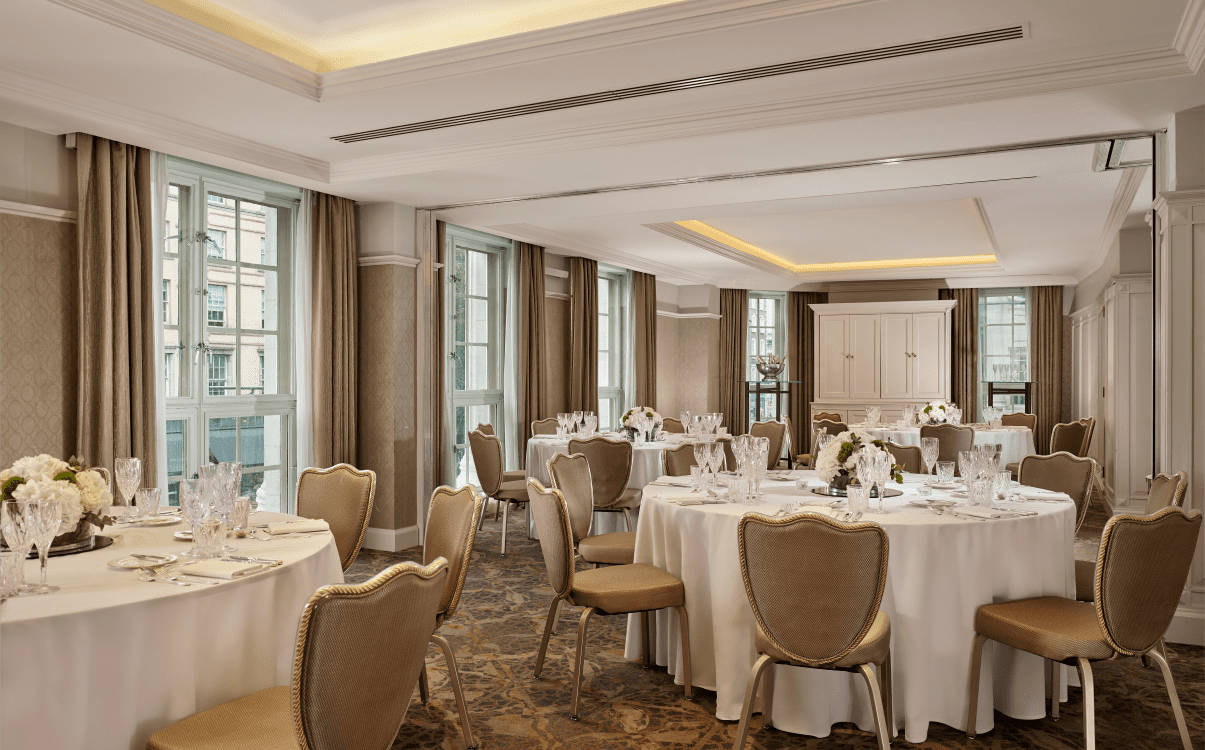 Meeting room set for banquet dinner with white cloths and gold chairs in The College Green Hotel Dublin