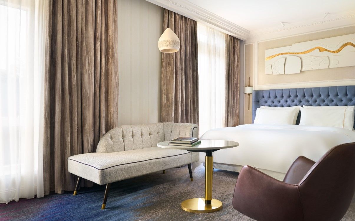 Deluxe king room with large windows and blue headboard