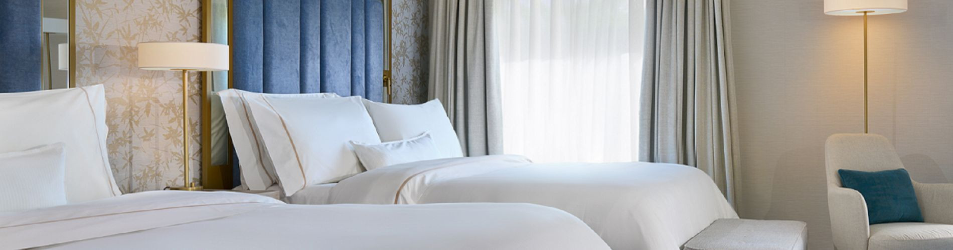 Two queen beds with closed curtains in The College Green Hotel Dublin